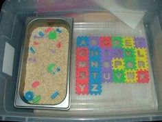 a plastic container filled with lots of different colored letters and numbers on top of it