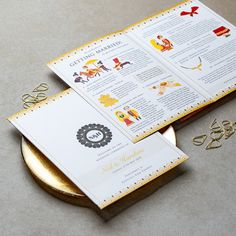 an open menu sitting on top of a gold plate