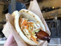 a hot dog with coleslaw and a sausage on it