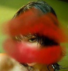 a blurry photo of a woman's face with her hair blowing in the wind