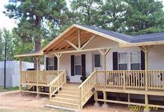 a mobile home with porches and steps leading to the front door is shown in this image