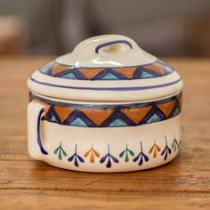 a ceramic container sitting on top of a wooden table