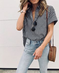 a woman wearing jeans and a checkered shirt