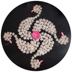 a black plate with white and pink designs on it's surface, in the shape of a flower