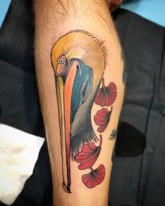 a close up of a person's leg with a bird and flowers on it