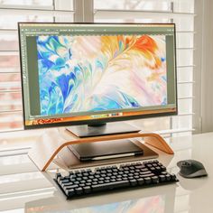 a desktop computer sitting on top of a white desk next to a keyboard and mouse