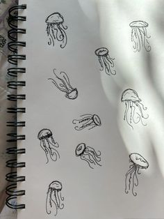 an open notebook with drawings of jellyfish on it