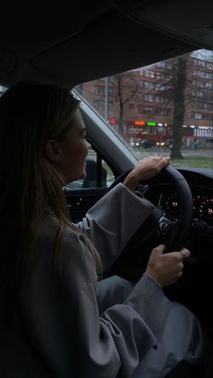 a woman sitting in the driver's seat of a car