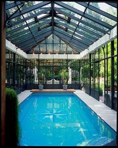 an indoor swimming pool surrounded by glass walls