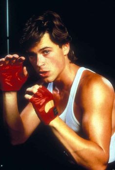 a young man wearing red boxing gloves