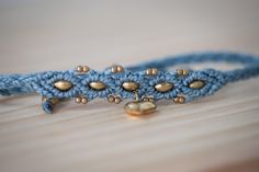 a close up of a bracelet on a wooden surface with beads and bells attached to it