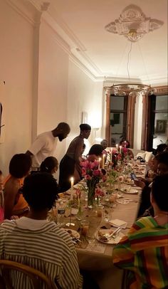 a group of people sitting around a long table