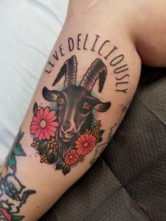 a goat with flowers on it's arm and the words live deliciously written in black ink