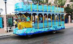 a blue and yellow bus driving down a street