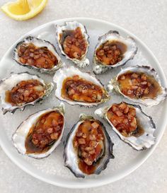 a white plate topped with oysters covered in sauce