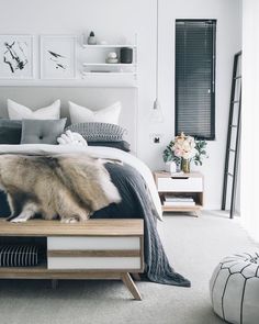 a bedroom with white walls and artwork on the wall