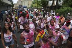 a group of people walking down a street covered in colored paint and holding onto each other