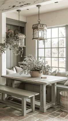 a dining room table with benches and potted plants