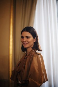 a woman standing in front of a curtain