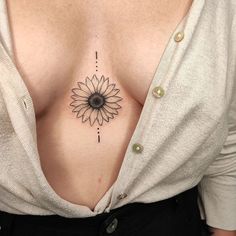 a woman's chest with a sunflower tattoo on her left side ribcage