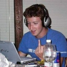 a man wearing headphones sitting in front of a laptop computer