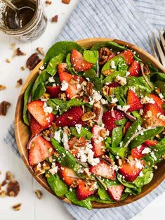 a salad with spinach, strawberries and feta cheese