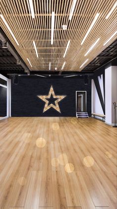 an empty dance studio with wooden floors and ceiling lights, stars on the wall above