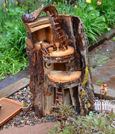 a tree stump with a chair and ladder in it