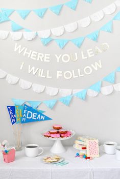 a table topped with cake and cupcakes next to a banner that says where you lead i will follow