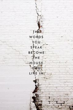 the words you speak become the house we live in written on a brick wall with peeling paint