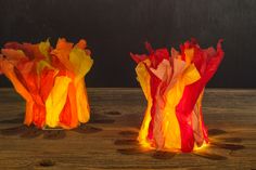 two colorful vases sitting on top of a wooden table next to eachother