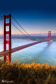 the golden gate bridge in san francisco, california at sunset with blue sky and water below