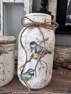 two jars with birds painted on them are sitting on the floor next to each other