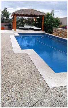 an empty swimming pool with a thatched roof