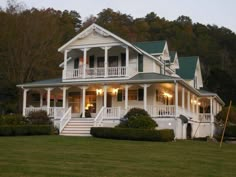 a large white house sitting on top of a lush green field