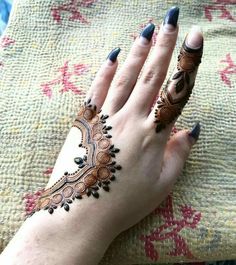 a woman's hand with hennap on it and black nail polishes