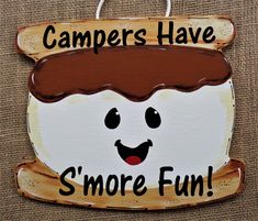 a wooden sign that says campers have s'more fun with a smiling face