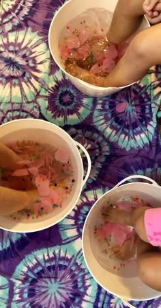 three people sitting in buckets filled with liquid