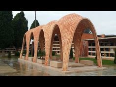 a group of arches sitting next to each other on top of a cement slab in front of a building