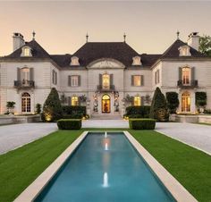 a large house with a pool in front of it and lots of grass on the ground