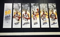 the banners are hanging on the wall in front of the basketball game scoreboard at the arena