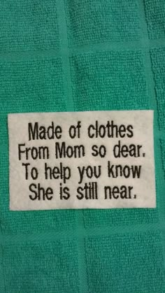 a green towel with a white label that says made of clothes from mom so dear to help you know she is still near