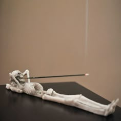 the skeleton is being held up by a needle and placed on top of a table