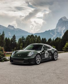 a green sports car parked in front of mountains