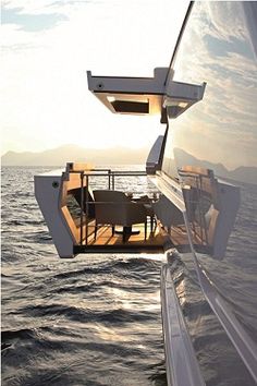 the dining table is on the deck of a boat in the middle of the ocean