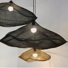 three lights that are hanging from some kind of net ceiling light fixture in a room