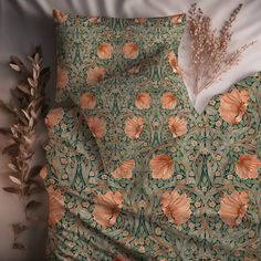 an orange and green floral pattern on a bed