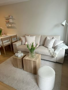 a living room filled with furniture and flowers on top of a white carpeted floor