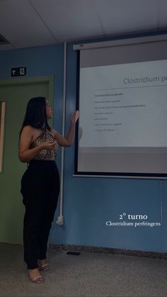 a woman standing in front of a projector screen