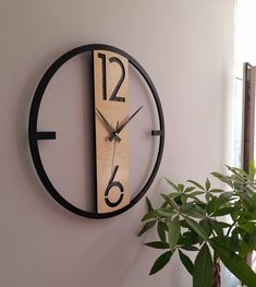 a clock on the wall next to a potted plant